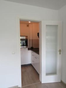 cocina con armarios blancos y puerta de cristal en Fewo Sonnenblick - Zentrumsnah und grün in Essen en Essen