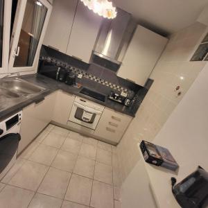 a small kitchen with a sink and a stove at GILMORE Home - close to PARIS center in La Courneuve