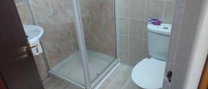 a bathroom with a shower with a toilet and a sink at Lynmoore Guest House in Blackpool