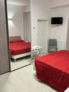 een slaapkamer met een spiegel en een rood bed bij Affittacamere “In Piazzetta” in Ateleta