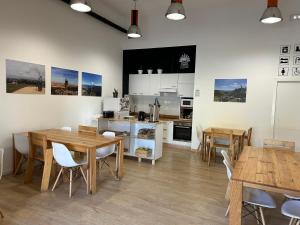 cocina y comedor con mesas y sillas de madera en Albergue SCQ, en Santiago de Compostela