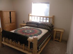 a bedroom with a wooden bed and a window at Cozy Cabin LaPine in La Pine