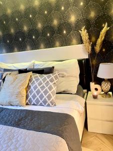 um quarto com uma cama com uma parede em preto e dourado em Apartamenty Kielce- Apartament Komfort przy Baseny Tropikalne, Kadzielnia, parking, faktura em Kielce
