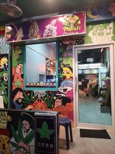 una tienda con una pared cubierta de graffiti colorido en เวทย์​มนต์​กัญชาไทย​ จาก​ ฟาร์ม​สุรินทร์​, en Pattaya central