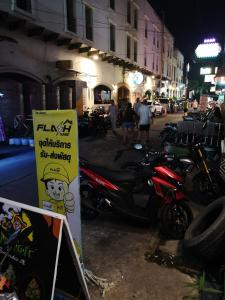 un grupo de motocicletas estacionadas en una calle por la noche en เวทย์​มนต์​กัญชาไทย​ จาก​ ฟาร์ม​สุรินทร์​, en Pattaya central