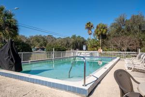 a swimming pool with chairs and a table and chairs at Suwannee Gables in Old Town