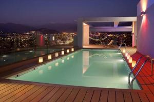 a swimming pool on top of a building with a city at Apartment Cerro Colorado in Santiago