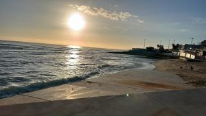 a beach with the sun rising over the water at MAR VERDE - Parede-Cascais in Parede