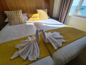 a bed with towels on it with a window at Marina Metro Hotel in Saint Helier Jersey