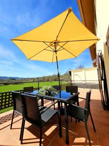 una mesa con una sombrilla amarilla en el patio en El Rincón del Pirineo, en Senegüé