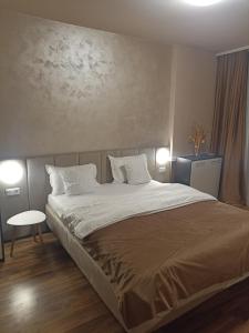 a bedroom with a large bed with white pillows at SuiteMateo in Cluj-Napoca