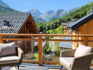 a balcony with two chairs and a view of mountains at Chalet Valloire, 7 pièces, 14 personnes - FR-1-263-532 in Valloire