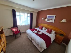 a bedroom with a large bed with two shoes on it at Marina Metro Hotel in Saint Helier Jersey
