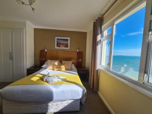 ein Schlafzimmer mit einem großen Bett und einem großen Fenster in der Unterkunft Marina Metro Hotel in Saint Helier Jersey