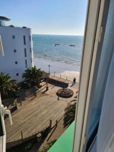 a view of the beach from a balcony of a building at Marina Metro Hotel in Saint Helier Jersey