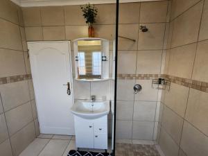 a bathroom with a sink and a mirror at Nkulies Nest in Centurion