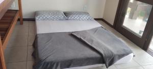 Dos camas en una habitación con ventana. en Hostel de gaia, en Santa Cruz do Sul