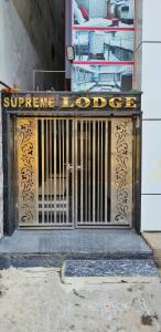 un cancello con un cartello sopra di fronte a un edificio di Supreme Hotels 2.0 a Warangal