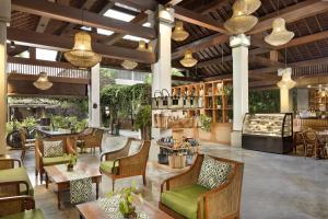 a restaurant with chairs and tables and a bar at Adiwana Unagi Suites in Ubud