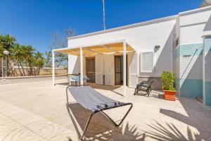 a chair on a patio in front of a building at Casa vacanze Tafuro in Punta Prosciutto