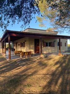 a white building with a porch and some chairs at La Pausa. Casa de campo in Deán Funes