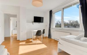 Sala de estar blanca con sofá blanco y escritorio en BEGE APARTMENTS WorkAway Residence, en Bochum