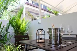 a table with wine glasses on a balcony with plants at Lovely Townhouse in Laguna Park in Thalang