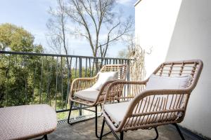 3 sillas de mimbre sentadas en un balcón con árboles en Les Terrasses de Louise, en Burdeos