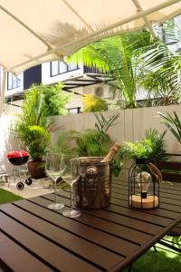 einen Tisch mit Weingläsern und Pflanzen auf einer Terrasse in der Unterkunft Lovely Townhouse in Laguna Park in Thalang