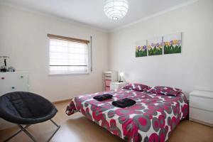 a bedroom with a bed and a chair in it at Ferrel Casual Home - Baleal in Ferrel