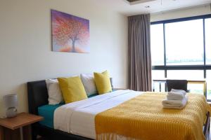 1 dormitorio con 1 cama grande con almohadas amarillas en Lovely Townhouse in Laguna Park en Thalang