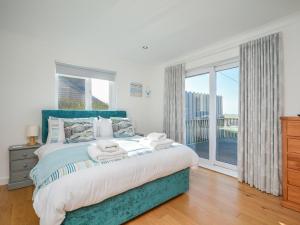 a bedroom with a large bed and a large window at 4 Bed in Tintagel 75335 in Forrabury
