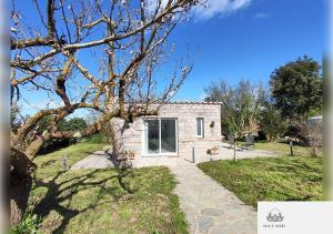 a stone house with a tree in the yard at Gaia's House in Massa Lubrense