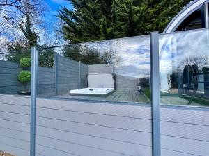 a glass enclosure with a tub on a deck at Tanglewood Loft in Newry