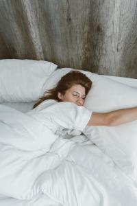 Una mujer acostada en la cama con una almohada en Posta Natural en Tandil