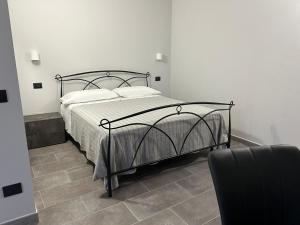 a bed in a white room with a black frame at B&B Il Gelsomino in Fontanelle di Roccabianca