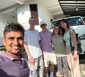 a group of people standing in front of a car at Niro Home Kamburugamuwa in Kamburugamuwa