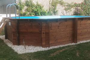 a swimming pool in a backyard with a table at Maison à la campagne avec piscine 12 pers in Genouillé