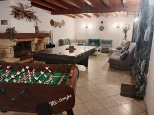 a living room with a pool table and a fireplace at Maison à la campagne avec piscine 12 pers in Genouillé