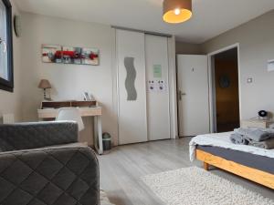 a bedroom with a bed and a chair and a desk at La Soranaise, chambre chez habitant à la campagne in Sorans-lès-Breurey