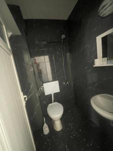 een zwarte badkamer met een toilet en een wastafel bij THE BEACH OTEL DİDİM in Didim