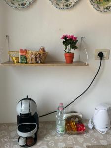 eine Kaffeemaschine auf einer Theke mit einem Regal in der Unterkunft Sweet home in Varese