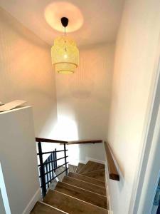 pasillo con escalera y lámpara de araña en Villa, en Sainte-Eulalie