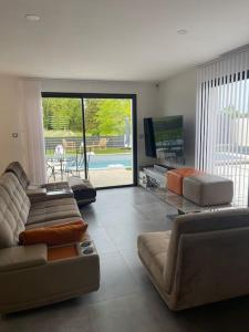 Sala de estar con 2 sofás y TV en Villa, en Sainte-Eulalie