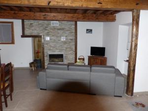 a living room with a couch and a fireplace at Maison de vacances in Melles