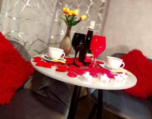 a table with red flowers and wine glasses on it at Hortensja 309 in Koszalin
