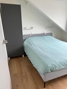 a bedroom with a bed and an open door at Guesthouse West in Noordwijk