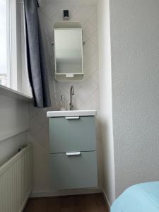 a bathroom with a sink and a mirror at Guesthouse West in Noordwijk +19 photos