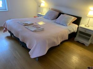 - une chambre avec un grand lit et des serviettes dans l'établissement B&B Agnes, à Vlissegem