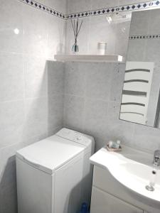 a white bathroom with a sink and a washing machine at Casa Marina - Le Petit Bleu Vue mer in Pornic